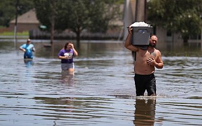 Clint Guedry carries a container full of items he retrieved from his girlfriend's flooded home on August 17, 2016 in Sorrento, Louisiana. (Joe Raedle/Getty Images/AFP)