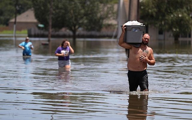 Clint Guedry carries a container full of items he retrieved from his girlfriend's flooded home on August 17, 2016 in Sorrento, Louisiana. (Joe Raedle/Getty Images/AFP) Clint Guedry carries a container full of items he retrieved from his girlfriend's flooded home on August 17, 2016 in Sorrento, Louisiana. (Joe Raedle/Getty Images/AFP)