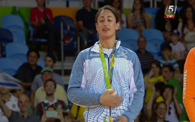 Israeli judoka Yarden Gerbi clutches her bronze medal for the women's under-63kg category during the awards ceremony at the Olympic Games in Rio on August 9, 2016 (screen capture: Channel 55)