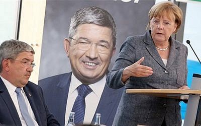 German Chancellor Angela Merkel speaks alongside Lorenz Caffier, left, of Merkel's Christian Democrats, during an election campaign in Neustrelitz, Germany on Aug. 17, 2016. (Bernd Wuestneck/dpa via AP) German Chancellor Angela Merkel speaks alongside Lorenz Caffier, left, of Merkel's Christian Democrats, during an election campaign in Neustrelitz, Germany on Aug. 17, 2016. (Bernd Wuestneck/dpa via AP)
