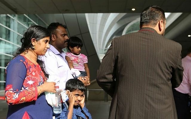 A family who were passengers aboard an Emirates jetliner that crash-landed are helped to a taxi in Dubai, United Arab Emirates, on Wednesday, Aug. 3, 2016. (AP Photo/Jon Gambrell)