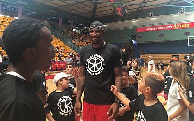 Illustrative: Amar’e Stoudemire is surrounded by young fans at his youth basketball camp in Jerusalem, August 8, 2016. (Andrew Tobin)
