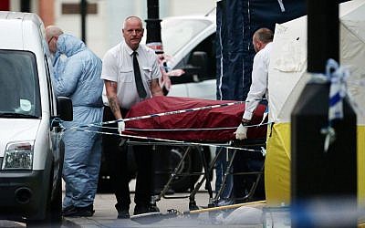 A body is removed from the scene in Russell Square, central London, after a knife attack Thursday, August 4, 2016. (Yui Mok/PA via AP)