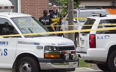 Police stand in front of a house in Scarborough, Ont., on Thursday, Aug. 25 , 2016, after three people were killed in a crossbow incident. (Chris Young/The Canadian Press via AP)
