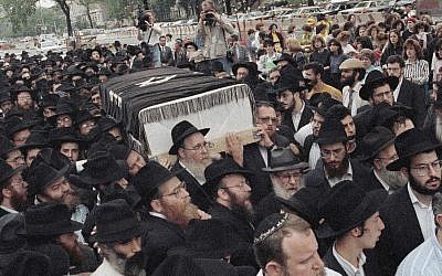 In this Aug. 21, 1991, file photo, the casket of Yankel Rosenbaum, a rabbinical student visiting from Australia, is carried through the streets of the Crown Heights section of the Brooklyn borough of New York. (AP/David Burns, File)