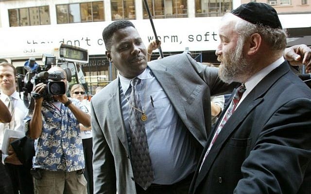 File: In this Aug. 19, 2002, file photo, Carmel Cato, center, reaches out to embrace Norman Rosenbaum, right, as they walk together in a show of unity into a New York restaurant on the 11th anniversary of the 1991 Crown Heights riots sparked by the deaths of Cato's 7-year-old son Gavin Cato and the murder of Rosenbaum's brother Yankel, an Australian doctoral student. On Sunday, Aug. 21, 2016, residents of the Crown Heights neighborhood in Brooklyn mark the 25th anniversary of the riot. (AP Photo/Beth A. Keiser, File) File: In this Aug. 19, 2002, file photo, Carmel Cato, center, reaches out to embrace Norman Rosenbaum, right, as they walk together in a show of unity into a New York restaurant on the 11th anniversary of the 1991 Crown Heights riots sparked by the deaths of Cato's 7-year-old son Gavin Cato and the murder of Rosenbaum's brother Yankel, an Australian doctoral student. On Sunday, Aug. 21, 2016, residents of the Crown Heights neighborhood in Brooklyn mark the 25th anniversary of the riot. (AP Photo/Beth A. Keiser, File)