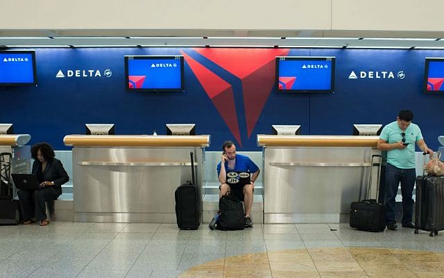 Passengers wait at the Delta ticket counter at Hartsfield–Jackson Atlanta International Airport, Monday, Aug. 8, 2016, in Atlanta, Georgia. (AP Photo/Branden Camp)