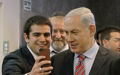 Prime Minister Benjamin Netanyahu poses for a selfie with student on March 30, 2014 (Danny Meron/POOL/Flash90)