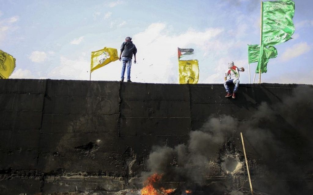 Flags of Fatah, Hamas and other Palestinian movements atop the West Bank security barrier during a protest in November 2015. (illustrative photo: Muammar Awad/FLASH90)