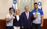 Prime Minister Benjamin Netanyahu and his wife Sara seen with Israeli judokas and Olympic medalists Ori Sasson and Yarden Gerbi during a meeting with sport's delegation to the 2016 Rio Olympics Games, at the Prime Minister's Office in Jerusalem, August 17, 2016. (Amit Shabi/Pool)