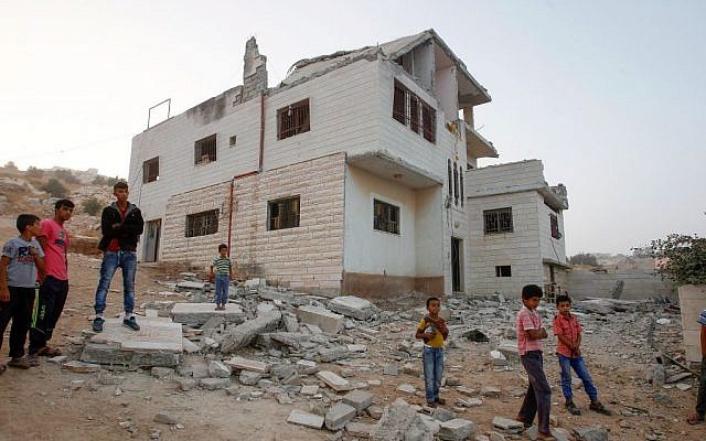 Palestinians check the damage in the house of Mohammad Mahamra after it was demolished by the army in Yatta, south of Hebron, August 4, 2016. Wisam Hashlamoun/Flash90)