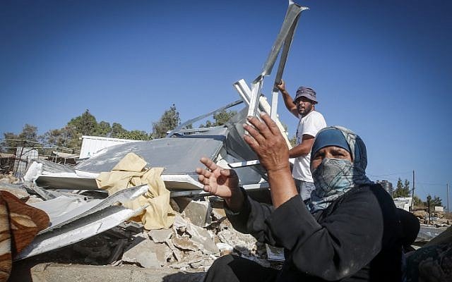 The Palestinian Hathaleen family seen at the ruins of their sheds demolished by Israeli troops in the West Bank village of Um Alkhair, south of Hebron on August 9, 2016. (Wisam Hashlamoun/Flash90 )