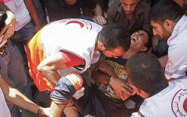 A wounded Palestinian is evacuated by medical staff during clashes with Israeli soldiers in the al-Fawar refugee camp on August 16 2016. (Wisam Hashlamoun/Flash90)