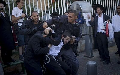 Ultra-Orthodox Jewish men protest against the arrest of a Jewish seminary students who failed to comply with a recruitment order, next to the army recruiting office in Jerusalem on August 21, 2016. (Yonatan Sindel/Flash90)