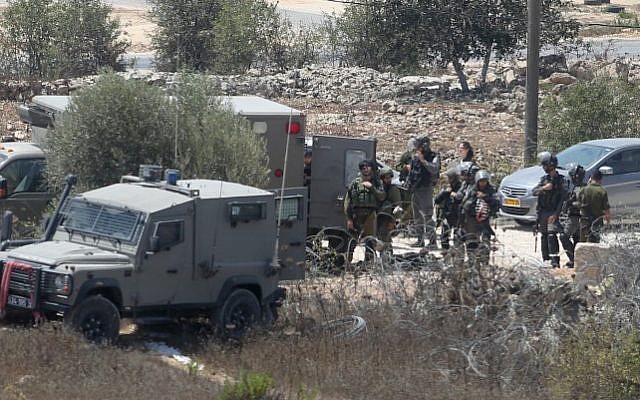 Israeli security forces at the scene where Iyad Hamad, a Palestinian man was shot dead by Israeli soldiers after running towards a guard post near the West Bank village of Silwad, August 26, 2016. (Flash90) Israeli security forces at the scene where Iyad Hamad, a Palestinian man was shot dead by Israeli soldiers after running towards a guard post near the West Bank village of Silwad, August 26, 2016. (Flash90)