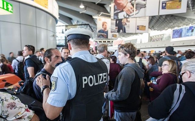 Illustrative: A policeman talks to travelers in the departure area at Frankfurt airport, central Germany (Frank Rumpenhorst/dpa via AP) Illustrative: A policeman talks to travelers in the departure area at Frankfurt airport, central Germany (Frank Rumpenhorst/dpa via AP)