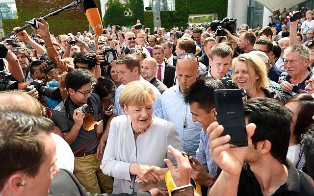 German Chancellor Angela Merkel greets members of the public at the Federal Chancellery during the 18th open day of the German Federal Government in Berlin, Germany, August 28, 2016. (Rainer Jensen/dpa via AP)