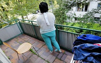 In this July 28, 2016 picture 17-year-old Yazidi girl stands on the balcony of her home in Germany. After escaping the clutches of Islamic State, Yasmin, a Yazidi girl, was so traumatized by her captivity that she poured gasoline on herself and set it alight - hoping to render herself no longer desirable to the extremists. Two years later, she’s being treated in Germany not only for her physical wounds, but for the psychological damage that led her to her act of desperation. (AP Photo/Michael Probst)
