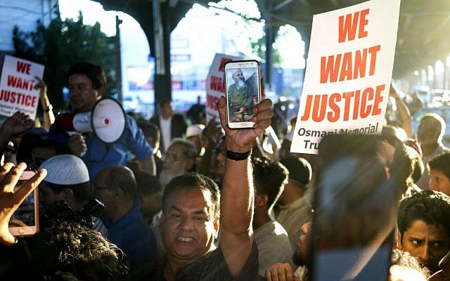 People gather for a demonstration Saturday, Aug. 13, 2016, near a crime scene after the leader of a New York City mosque and an associate were fatally shot in a brazen daylight attack as they left afternoon prayers. (AP Photo/Craig Ruttle)