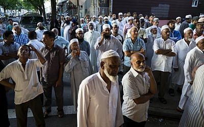 People gather near a crime scene for a demonstration after the leader of a New York City mosque and an associate were fatally shot in a brazen daylight attack as they left afternoon prayers Saturday, August 13, 2016. Police said 55-year-old Imam Maulama Akonjee and his 64-year-old associate, Tharam Uddin, were shot in the back of the head as they left the Al-Furqan Jame Masjid mosque in the Ozone Park section of Queens shortly before 2 p.m. (AP Photo/Craig Ruttle)