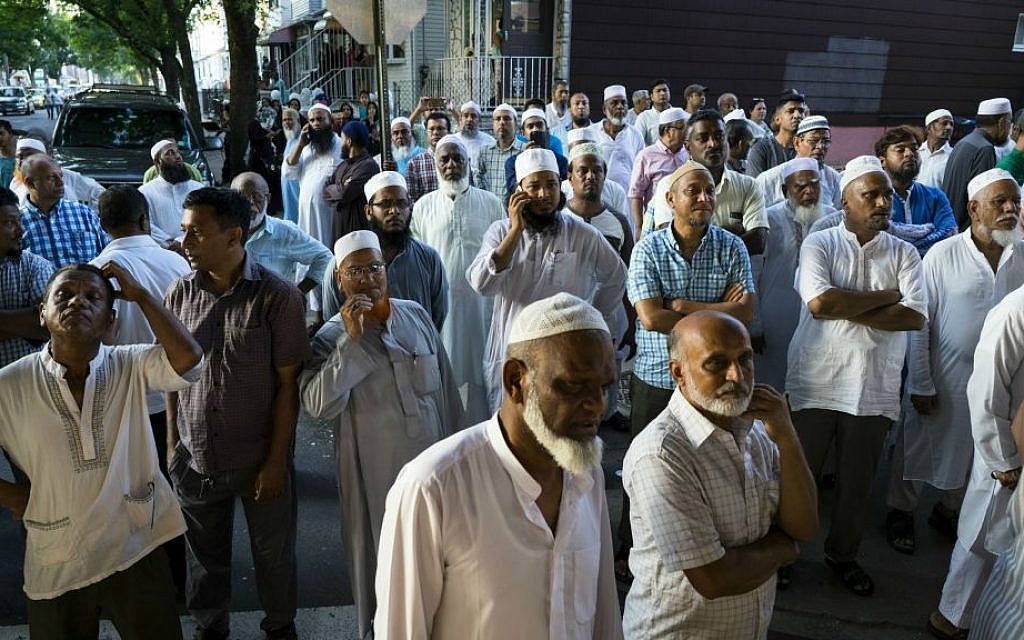 In this Saturday, Aug. 13, 2016 photo, people gather near a crime scene for a demonstration after the leader of a New York City mosque and an associate were fatally shot in a brazen daylight attack as they left afternoon prayers Saturday. (AP Photo/Craig Ruttle)