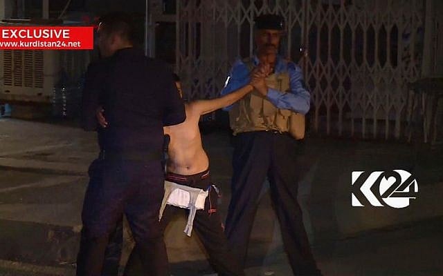 Still taken from local TV footage, showing a child being restrained by security forces, holding his arms out-stretched as another man cuts off a belt of explosives, August. 21, 2016, in Kirkuk, Iraq. (Kurdistan 24 TV news via AP) 
