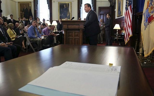 New Jersey Gov. Chris Christie addresses a gathering after signing legislation at the Statehouse that would bar the state's public pension fund from investing with companies that boycott Israel or Israeli businesses, Tuesday, Aug. 16, 2016, in Trenton, New Jersey. (AP Photo/Mel Evans)