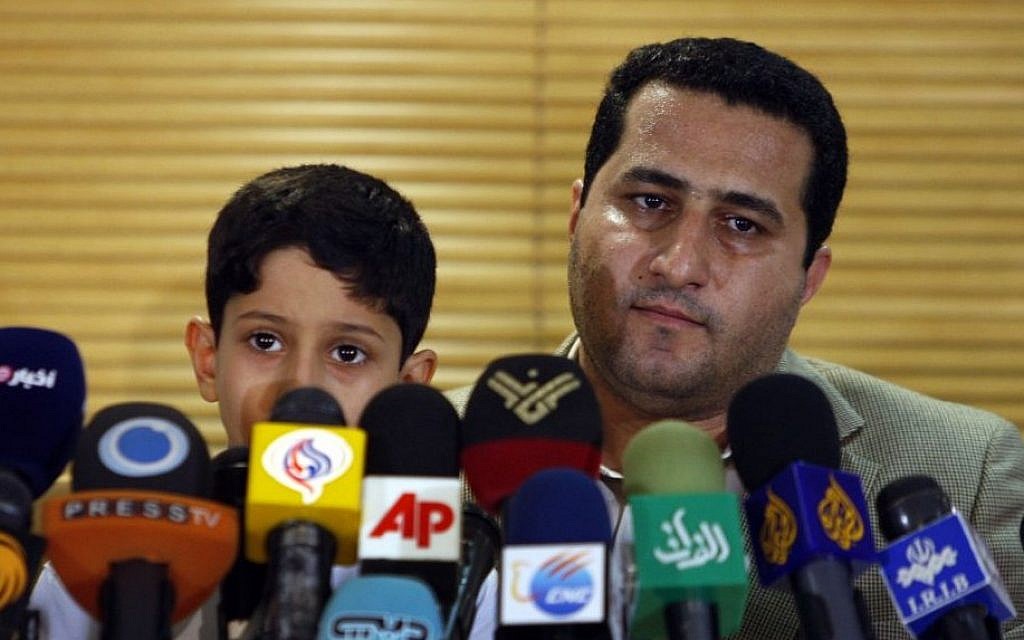 Shahram Amiri, an Iranian nuclear scientist attends a news briefing while holding his son Amir Hossein as he arrives at the Imam Khomeini airport just outside Tehran, Iran, after returning from the United States on July 15, 2010. (AP/Vahid Salemi)