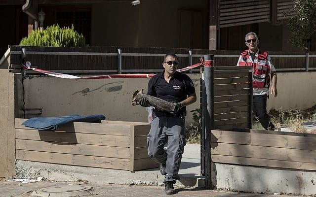 An Israeli police sapper carries part of a rocket which landed in a yard of a house in the city of Sderot, southern Israel, Sunday, August 21, 2016. (AP/Tsafrir Abayov) An Israeli police sapper carries part of a rocket which landed in a yard of a house in the city of Sderot, southern Israel, Sunday, August 21, 2016. (AP/Tsafrir Abayov)