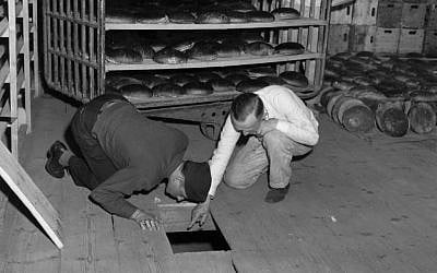 US Lt. Robert R, Rogers, left, and Erich Pinkau, of the German criminal police, examine the under-floor hiding place where arsenic was found in a Nuremberg, Germany bakery which supplied bread to Stalag 13, April 1946. (US Army Signal Corps via AP) US Lt. Robert R, Rogers, left, and Erich Pinkau, of the German criminal police, examine the under-floor hiding place where arsenic was found in a Nuremberg, Germany bakery which supplied bread to Stalag 13, April 1946. (US Army Signal Corps via AP)