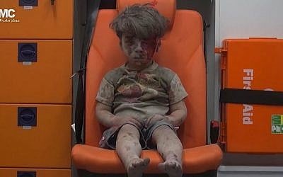 In this frame grab taken from video provided by the Syrian anti-government activist group Aleppo Media Center (AMC), a child sits in an ambulance after being pulled out or a building hit by an airstirke, in Aleppo, Syria, Wednesday, Aug. 17, 2016. (Aleppo Media Center via AP)