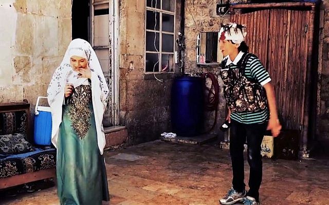 This undated frame grab from video provided by Bashar Sakka, producer of the sit-com, “Um Abdou the Aleppan,” shows Syrian actor Qusai Abtini, right, while filming an episode with Rasha, left, known as Umm Abdu, in the northern Syrian city of Aleppo, Syria. (Bashar Sakka via AP)