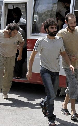 In this Saturday, Sept. 1, 2012, file photo, Syrian prisoners file out of a bus before their release from custody at the Damascus Police Command headquarters in Damascus, Syria. (AP Photo/Bassem Tellawi, File)
