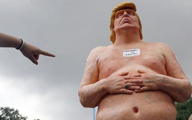 A woman points at a statue of a naked Republican presidential candidate Donald Trump. (AP/Mary Altaffer)