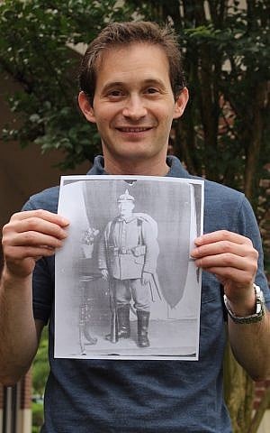 Baltimore jeweler Noam Efron holding a copy of the portrait he found of Siegfried Lamm at an estate sale for $9. (Hillel Kuttler/via JTA)