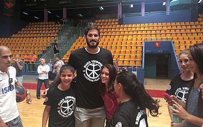 Omri Casspi posing for photos with kids at Amare Stoudemire’s basketball camp in Jerusalem, August 8, 2016. (Andrew Tobin)