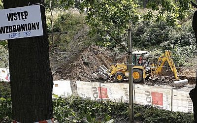 A sign warns against 'trespassing,' as heavy machinery begins the search to find a legendary Nazi train laden with treasure and armaments in Walbrzych, Poland, August 16, 2016. (AP Photo/Dariusz Gdesz)