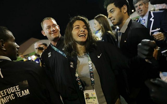 Refugee Olympic Team's Yusra Mardini, center, smiles during a welcome ceremony held at the Olympic village ahead of the 2016 Summer Olympics in Rio de Janeiro, Brazil, Wednesday, Aug. 3, 2016. (AP Photo/Jae C. Hong)