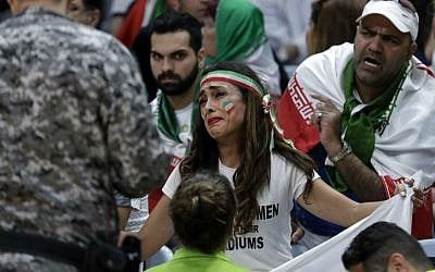 Iranian activist Sarai Darya pleads with Rio Olympics workers and security personnel as they consider removing her for holding up a large sign protesting the fact that women have not been allowed to attend volleyball matches in Iran, during a men's preliminary volleyball match between Egypt and Iran at the 2016 Summer Olympics in Rio de Janeiro, Brazil, Saturday, Aug. 13, 2016. (AP Photo/Jeff Roberson)
