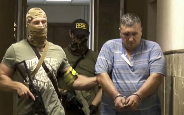In this screen grab taken from footage provided by the Russian Federal Security Service Press Service, a handcuffed man identified as Yevgeny Panov, suspected of being involved in a group that Russia's Federal Security Service (FSB) identified as Ukrainian 'saboteurs,' is led by FSB officers in Crimea, on Thursday, Aug. 11, 2016. (Russian Federal Security Service Press Service via AP) In this screen grab taken from footage provided by the Russian Federal Security Service Press Service, a handcuffed man identified as Yevgeny Panov, suspected of being involved in a group that Russia's Federal Security Service (FSB) identified as Ukrainian 'saboteurs,' is led by FSB officers in Crimea, on Thursday, Aug. 11, 2016. (Russian Federal Security Service Press Service via AP)