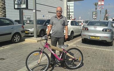 On August 17, 2016, Sami Jolles stands with the bicycle he purchased for 8-year-old Anwar Burqan, whose own bicycle had been destroyed after border guards in Hebron took it tossed it into some bushes. (Lonny Baskin)