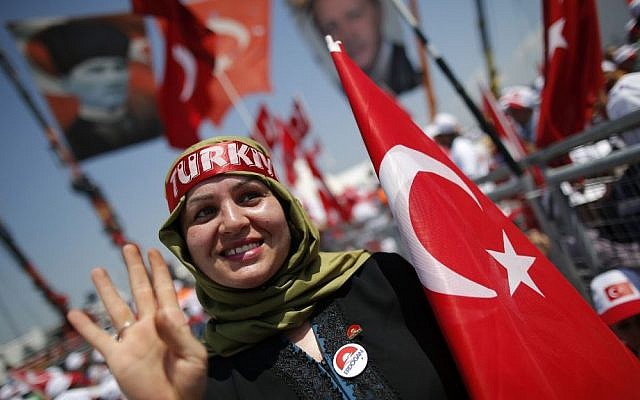 A Turkish woman waves as she holds her country's flag, during a Democracy and Martyrs' Rally in Istanbul, Sunday, Aug. 7, 2016. (AP Photo/Emrah Gurel)