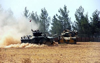 A Turkish army tank and an armored vehicle are stationed near the border with Syria, in Karkamis, Turkey, August. 23, 2016. (IHA via AP)