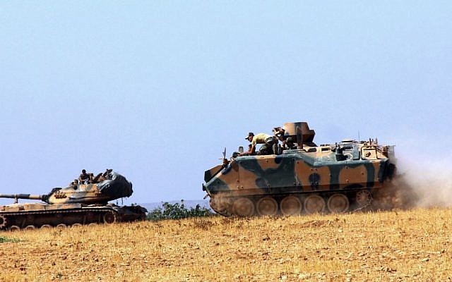 A Turkish army tank and an armored vehicle are stationed near the border with Syria, in Karkamis, Turkey, Tuesday, August 23, 2016. (IHA via AP)