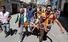 A wounded Palestinian is evacuated during clashes with the IDF in Al-Fawwar refugee camp south of Hebron, August 16 2016. (Wisam Hashlamoun/Flash90)