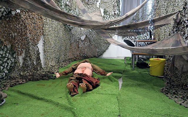A mannequin in one of the Medical Trauma Simulator's "single casualty rooms." The room is meant to mimic a forest environment, where soldiers may have to work on their hands and knees. (Luke Tress/Times of Israel)