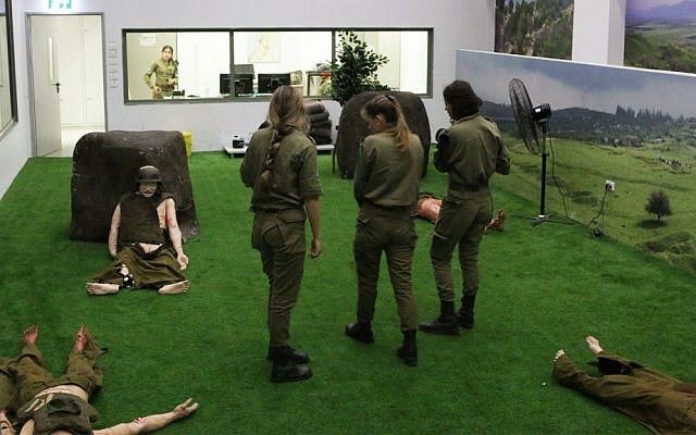 Instructors of the Medical Trauma Simulator prepare for an exercise in the multiple casualty event room. They can monitor the action from the floor or from the viewing room in back. (Luke Tress/Times of Israel)