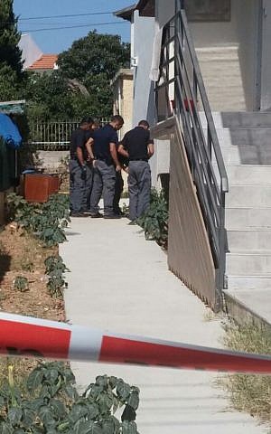 Police officers inspect a rocket fired from the Gaza Strip that landed in the town of Sderot in southern Israel on August 21, 2016. (Israel Police)