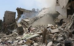 Syrian rescue workers search for victims through the rubble of a building destroyed during a reported barrel bomb attack in a rebel-held neighborhood in eastern Aleppo on August 27, 2016. (AFP PHOTO / THAER MOHAMMED)