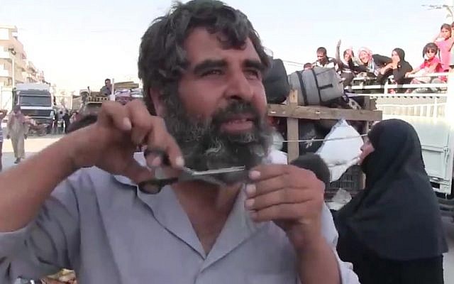 A Syrian man clips his beard after his town of Manbij was freed from Islamic State control, August 13, 2016. (Screenshot/K24)